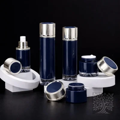 Deep navy glass bottles and cosmetic jars with silver lids, styled on tiered white platforms with caps set aside.