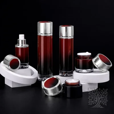 Black-to-red gradient glass packaging set with silver accents, featuring serum bottles and open cream jars on stands.