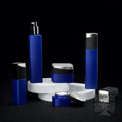 Deep cobalt blue bottles and jars with black accents, styled on tiered white stands with an open jar detail.