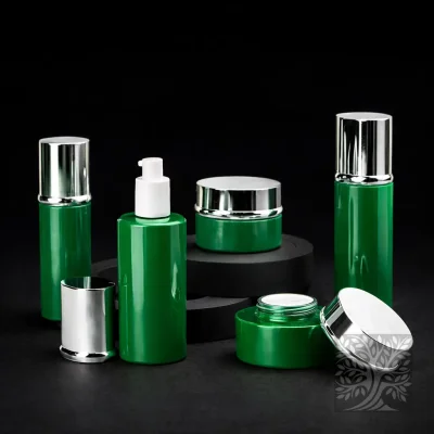 Gloss green bottles and cosmetic jars with chrome caps, displayed in a balanced studio layout on black risers.
