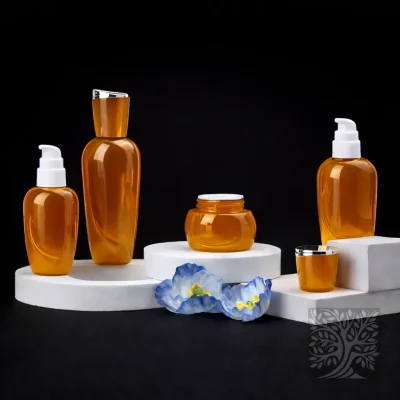 Warm amber glass skincare bottles and matching jars with gold caps, presented on white blocks with decorative flowers.