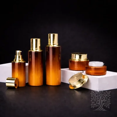 Amber gradient glass skincare bottles and jars with gold accents, arranged in a warm-toned Cocktail packaging display.