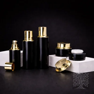 Gloss black glass skincare bottles and matching jars with gold caps, arranged on white platforms in a sleek composition.