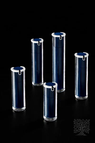 Navy blue acrylic serum bottles with silver caps and clear cylindrical outer shells, arranged in a refined modern grouping.