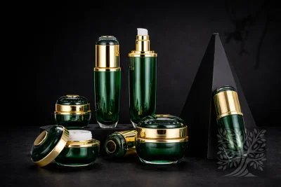 Emerald green acrylic skincare bottles and cosmetic jars with gold caps, displayed on black risers in a premium layout.