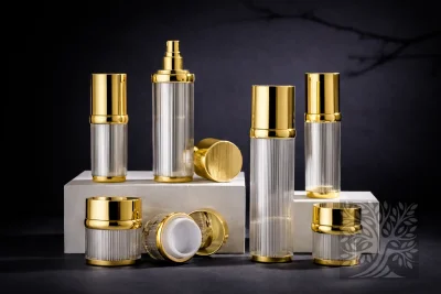 Clear ribbed acrylic bottles and jars with gold caps, neatly arranged on white stands with mixed open and closed jars.
